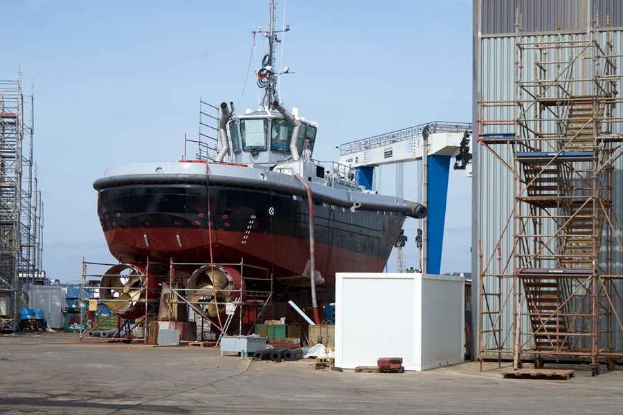 Vessel under construction on blocks in a shipyard with scaffolding